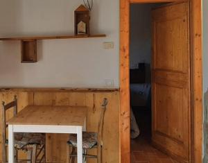 ウルビーノにあるカントリー ハウス カ ヴェルナッチァの木製テーブルと木製のドアが備わる部屋