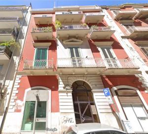 een rood-wit gebouw met balkons in een straat bij Archidante in Bari