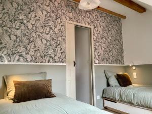 una camera con un letto e una parete con carta da parati di L'Adresse - Rempart Sud - Eguisheim avec garage privé a Eguisheim