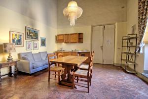 ein Wohnzimmer mit einem Tisch und einem Sofa in der Unterkunft Montegufoni by PosarelliVillas in Montagnana Val di Pesa