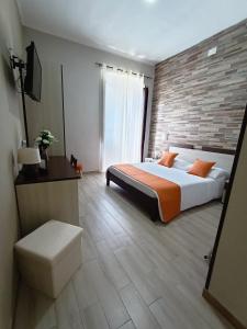 um quarto com uma cama grande e uma parede de tijolos em Domos La Corte Ghibellina em Iglesias