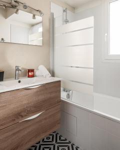 a bathroom with a sink and a tub and a mirror at Lake House 4 Bedroomed near Disneyland Paris in Serris +22 photos