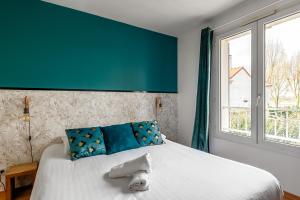 a bedroom with a large white bed with blue pillows at Lake House 4 Bedroomed near Disneyland Paris in Serris