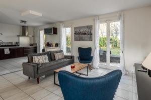 a living room with a couch and a table and chairs at Lake House 4 Bedroomed near Disneyland Paris in Serris