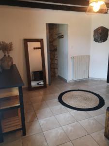 una camera con specchio e tappeto su un pavimento piastrellato di Agréable chambre privée avec entrée indépendante a Langeais