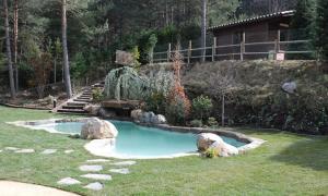 una pequeña piscina de agua con rocas en un patio en Cal Roig - Pedraforca, en Saldes