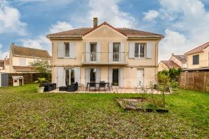 a house with a patio and a yard at Lake House 4 Bedroomed near Disneyland Paris in Serris