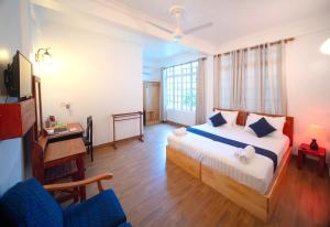 ein Schlafzimmer mit einem Bett und einem Schreibtisch in einem Zimmer in der Unterkunft Biosphere Inn in Dharavandhoo