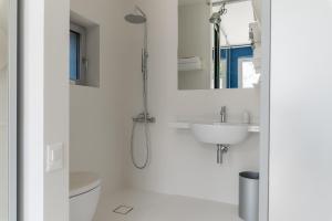 a white bathroom with a shower and a sink at Calcebianca in Ostuni