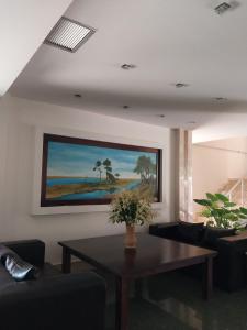 ein Wohnzimmer mit einem Tisch und einem Gemälde an der Wand in der Unterkunft Different Hotel & Restaurant in Divjaka