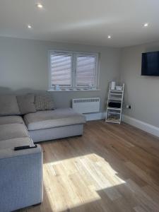 a living room with a couch and a tv at The Greenhouse in Wick