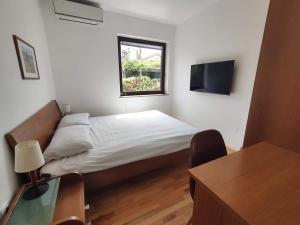 een kleine slaapkamer met een bed en een raam bij Apartments SeaView in Portorož