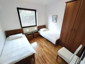 een kleine kamer met twee bedden en een raam bij Apartments SeaView in Portorož