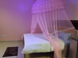 a bedroom with a bed with a canopy at Fresh World Hotel in Lira