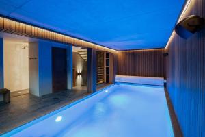a swimming pool in a house with blue lights at Chalet Getois in Les Gets