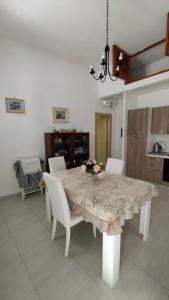a dining room table with white chairs and a tablecloth at Casa Rinuccia in Ischia