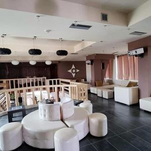 Großes Zimmer mit weißen Tischen und weißen Stühlen in der Unterkunft Different Hotel & Restaurant in Divjaka