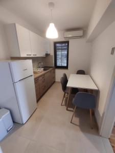 een keuken met een witte koelkast en een tafel en stoelen bij Apartments SeaView in Portorož +17 foto's