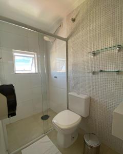 a bathroom with a toilet and a glass shower at Hotel Imperatriz in Telêmaco Borba