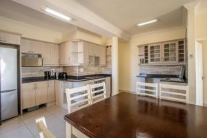 ウヴォンゴ・ビーチにあるSaints View Resort Unit 19の木製テーブルと家電製品付きの広いキッチン