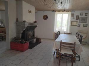 a dining room with a table and a fireplace at Chez Suzanne Maison à la campagne 2-8pers 4 chambres in Longeville-sur-la-Laines