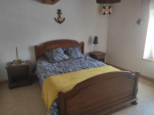 a bedroom with a large bed with a yellow blanket at Chez Suzanne Maison à la campagne 2-8pers 4 chambres in Longeville-sur-la-Laines