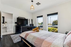 a bedroom with a bed and a flat screen tv at Enfield Executive in Gepps Cross