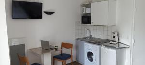 a kitchen with a washing machine and a sink at Cosy Studio La Defense in Courbevoie