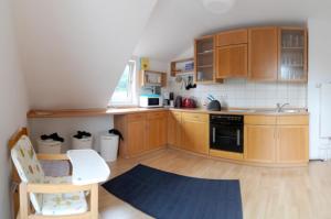a kitchen with wooden cabinets and a blue rug at Ferienwohnung Nr 3 in Wunstorf