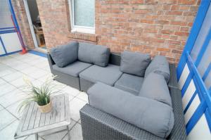 a couch sitting in front of a brick building at Ferienwohnung Nr 3 in Wunstorf +8 photos