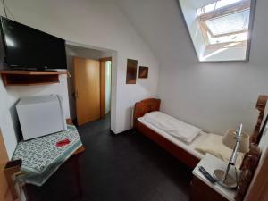 a small room with a small bed and a flat screen tv at Machlandgasthof Wahl in Ruprechtshofen