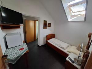 Kleines Zimmer mit einem kleinen Bett und einem Flachbild-TV. in der Unterkunft Frühstückspension Wahl in Ruprechtshofen