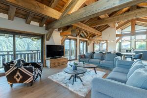 a living room with blue couches and a table at Chalet Getois in Les Gets