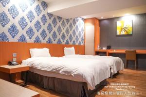 a bedroom with a large bed and a desk at Talmud Hotel Yizhong in Taichung