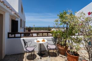a patio with a table and chairs on a balcony at Ilianthos Traditional Maisonette in Hersonissos