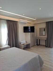 尼基亚娜Villa Don Kostangelo的配有一张床和一台平面电视的酒店客房