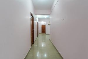 um corredor vazio com paredes brancas e uma porta em FabHotel Terra em Chennai
