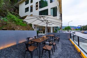 a table and chairs with an umbrella on a balcony at Mountain Luxury Courtyard Hotel-Zhangjiajie Wulingyuan National Forest Park-Laundry Service,coffee&Chinese Tea--Free airportpick-up or drop-off for Reserve of 4nights or more in Zhangjiajie