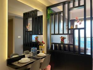 - une salle à manger avec une table, des chaises et des fenêtres dans l'établissement Comfort and Luxury Private Room at Goldcoast PIK, à Jakarta