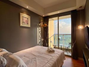 - une chambre avec un lit et une grande fenêtre dans l'établissement Comfort and Luxury Private Room at Goldcoast PIK, à Jakarta