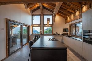 a large kitchen with a long table and some windows at Chalet Getois in Les Gets
