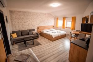 sypialnia z łóżkiem, kanapą i stołem w obiekcie APART Mikeš w Telczu