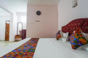 a bedroom with a large bed with colorful pillows at FabHotel Terra in Chennai