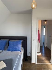 een slaapkamer met een bed met blauwe kussens en een hal bij Casa Marcu Wohnung 1 OG in Landkirchen