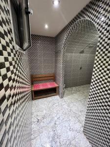 a bathroom with a shower with a bench and a tub at Hostel 3alame in Temara
