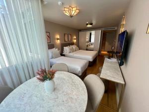 a hotel room with two beds and a table and chairs at Weingart Suites Hotel in Istanbul