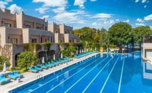 une grande piscine avec des chaises longues bleues en face d'un hôtel dans l'établissement Spice Hotel & Spa, à Belek