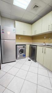 a kitchen with a refrigerator and a washing machine at Beach Apartment in Ras al Khaimah