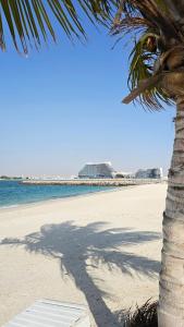 uma palmeira sentada numa praia com o oceano em Luxury Beach Apartment em Ras al-Khaimah