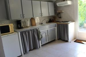 una cucina con mobili bianchi e un lavandino di Lou Pitchoun Cabanoun à Eygalières "2-3 Personnes" a Eygalières Altre 4 foto